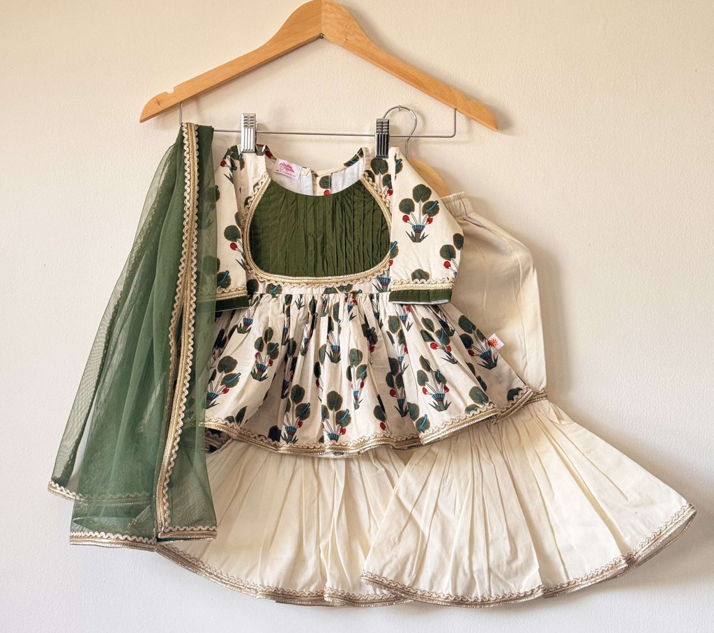 Girls' off-white and green floral cotton kurti and sharara set with a matching green net dupatta.