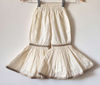 Girls' off-white tiered cotton sharara pants with gold lace detailing and an elastic waistband.