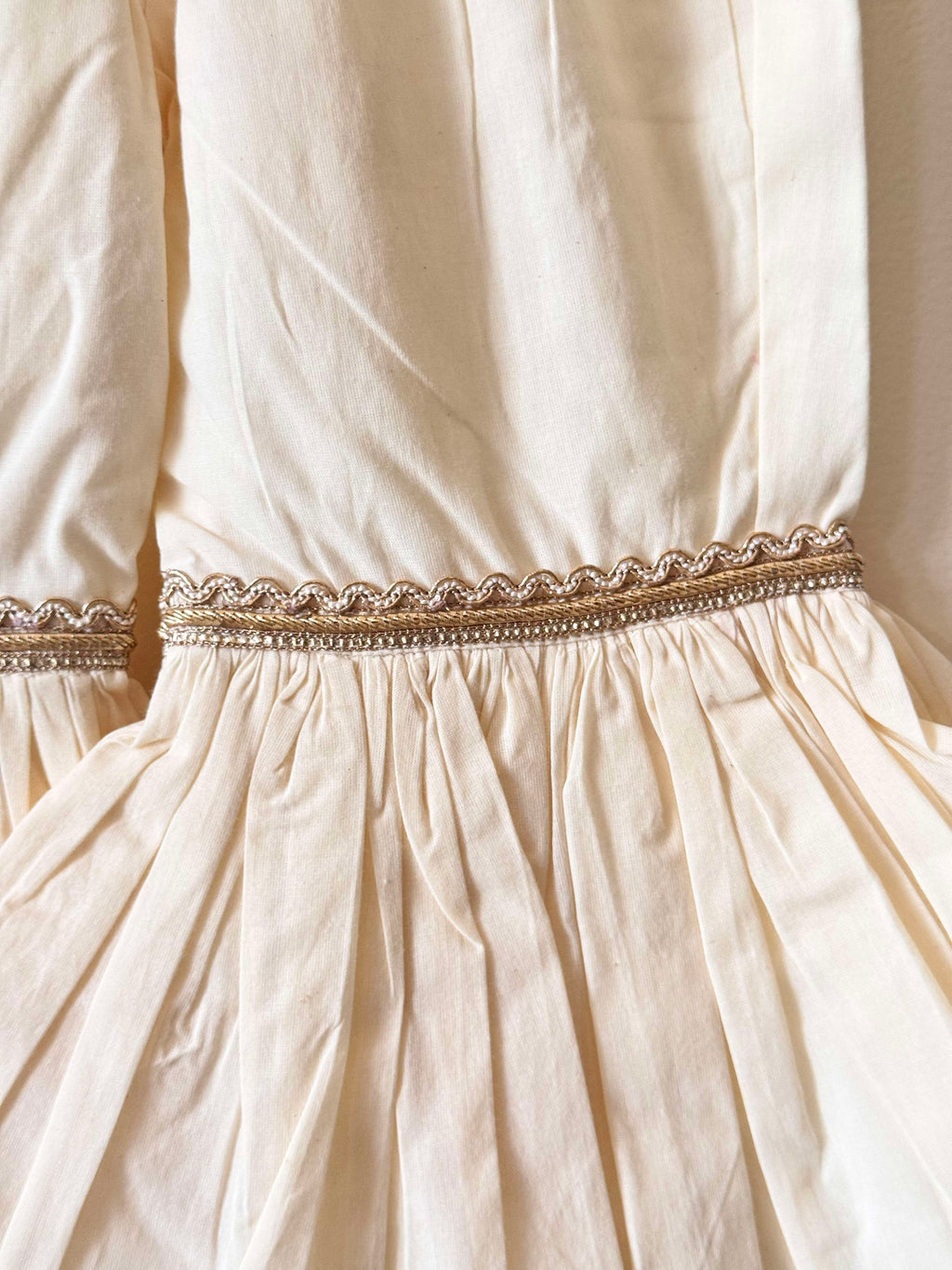 Close-up of a Girls' off-white tiered cotton sharara pants with gold lace detailing