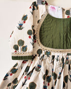 Close-up of an off-white floral print kurti with a dark green pintuck pleated bodice and gold lace detailing
