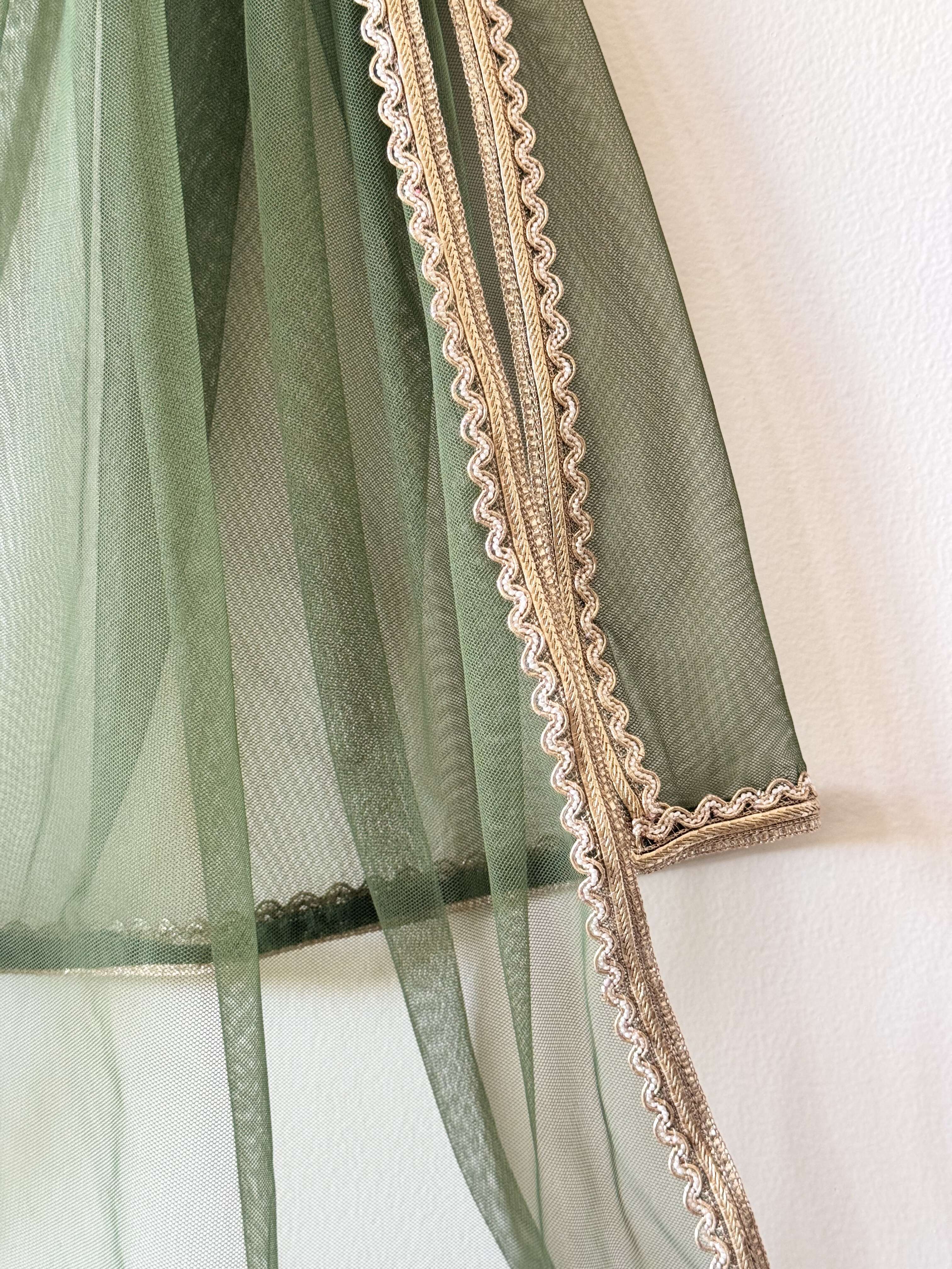a sheer green net dupatta with a gold lace border