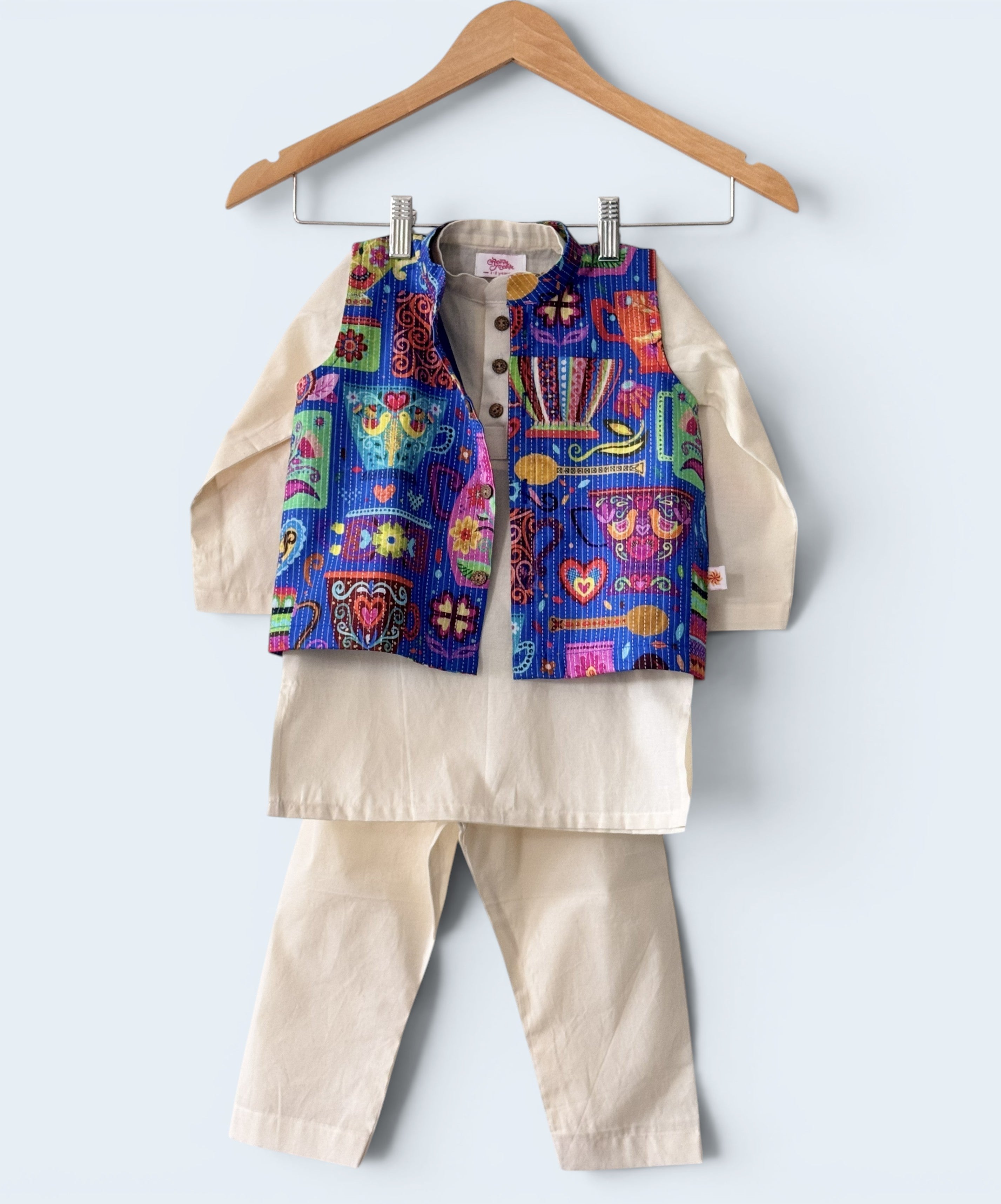 Boys 3-piece ethnic wear set featuring an off-white cotton kurta and pajama with a vibrant, multi-colored printed bandi jacket.